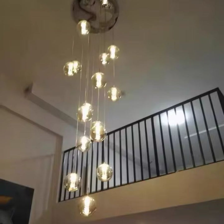 Suspension à globes en verre vue en hauteur, composition lumineuse élancée au style design pour espace à double hauteur