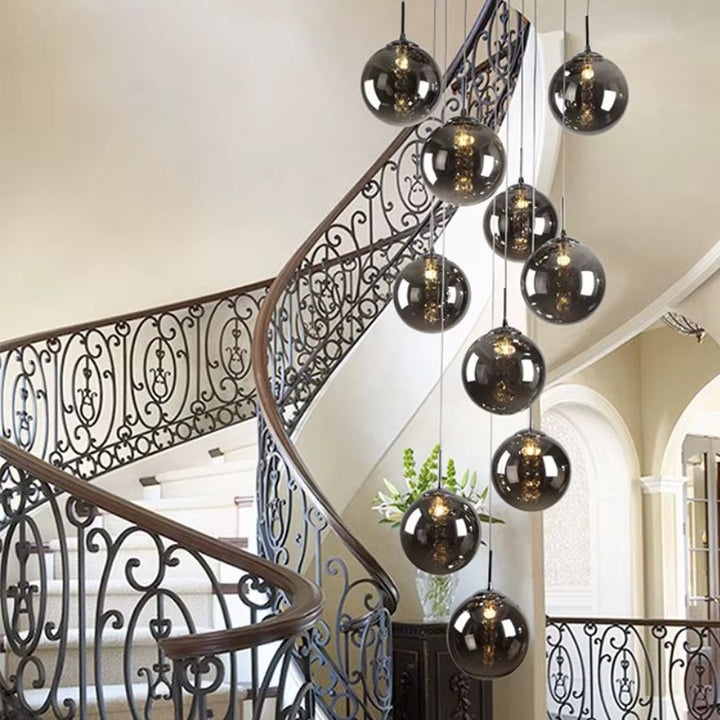 Suspension à globes en verre fumé en cascade, touche chic et contemporaine dans un escalier classique
