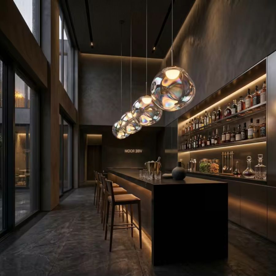 Alignement de globes en verre irisé dans un bar contemporain, suspension design aux reflets chaleureux et sophistiqués
