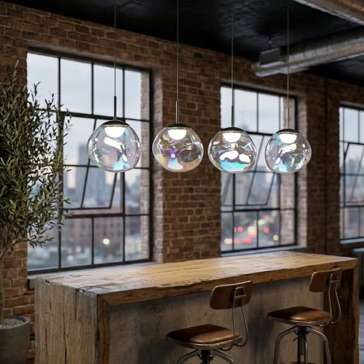 Suspension à quatre globes en verre irisé au-dessus d’un bar, dans un intérieur loft au style industriel contemporain