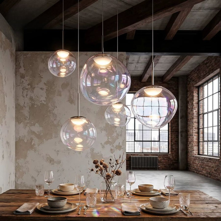 Suspension de globes en verre irisé au-dessus d’une table, dans une salle à manger au style loft industriel et chaleureux