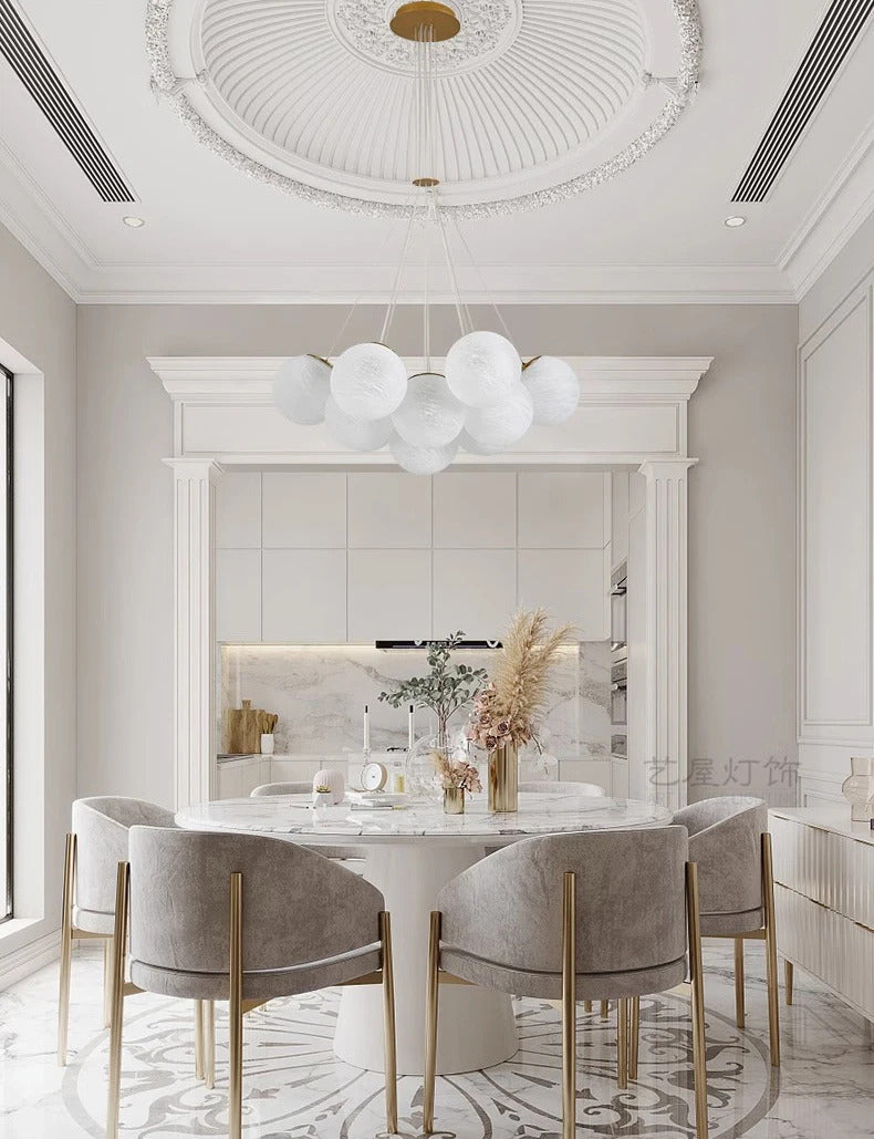Suspension  globes en verre opalin blanc au-dessus d'une table de salle à manger dans un intérieur classique chic