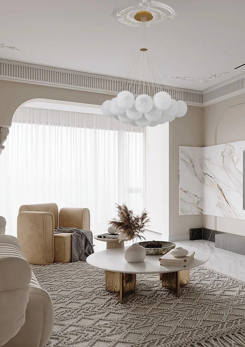 Suspension globes en verre opalin blanc au-dessus d'un salon lumineux au style classique contemporain