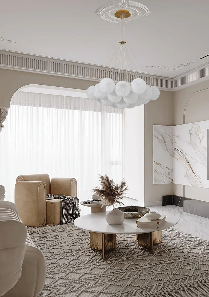 Suspension globes en verre opalin blanc au-dessus d'un salon lumineux au style classique contemporain