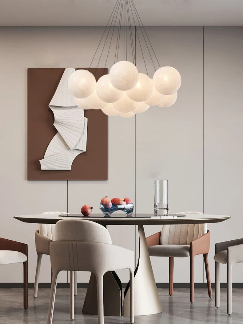Suspension globes en verre opalin blanc au-dessus d'une table de salle à manger au design contemporain