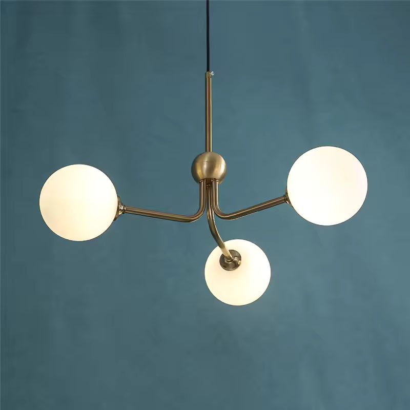 Suspension à trois globes en verre opalin et bras dorés asymétriques, au style rétro inspiré des années 50