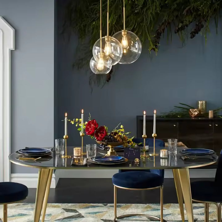 Au-dessus d’une table élégante, suspension à globes en verre transparent au style chic et contemporain
