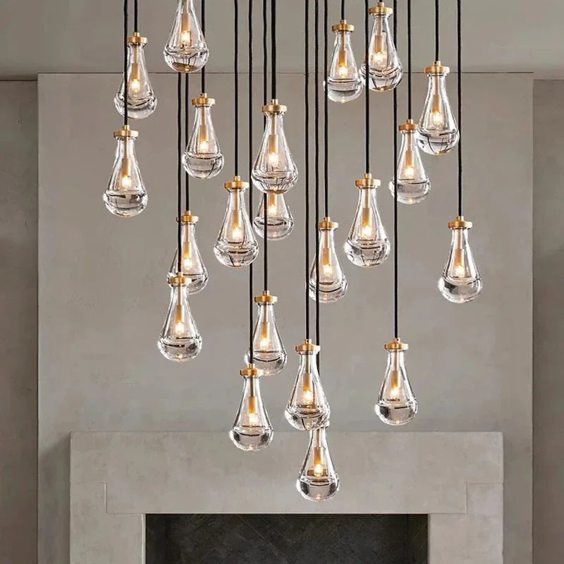 Suspension design en forme de goutte d'eau en verre et cuivre, idéale pour un éclairage moderne au-dessus d'une table.