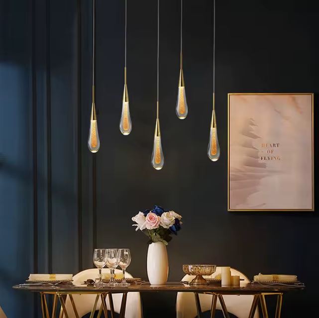 Suspension goutte d'eau en verre avec plusieurs lampes, parfaite pour illuminer une salle à manger avec style et élégance.