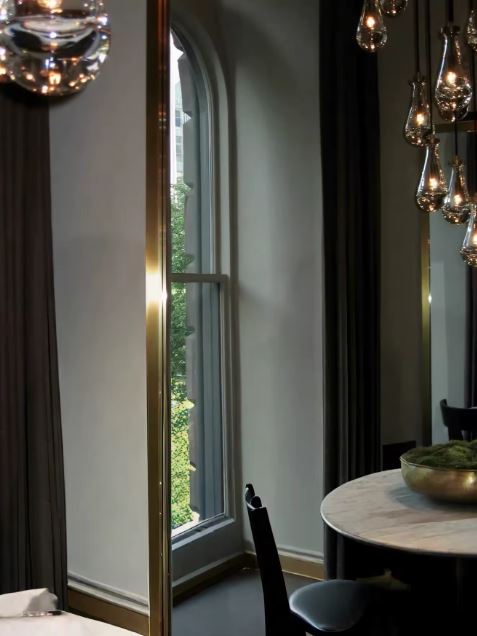 Suspension en gouttes de verre transparent avec finitions laiton au design sophistiqué inspiré de l'hôtellerie de luxe