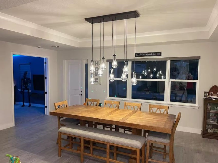 Suspension rectangulaire à gouttes en verre transparent, style contemporain raffiné au-dessus d'une table à manger
