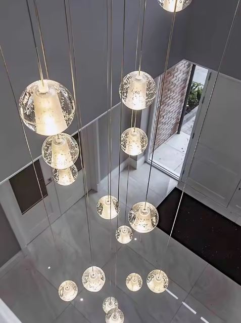 Suspension grande hauteur à globes en verre type cristal suspendus, idéale pour entrée moderne et éclairage décoratif aérien.