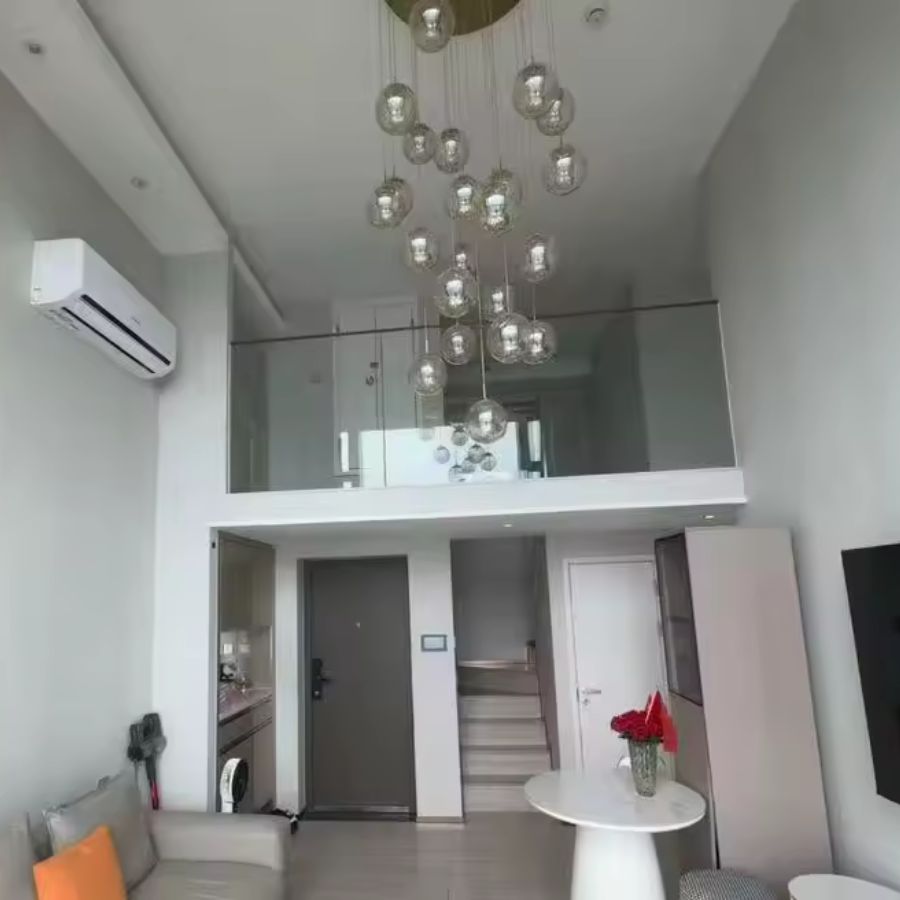 Grande suspension à globes en verre suspendus, composition aérienne et contemporaine dans un séjour avec mezzanine
