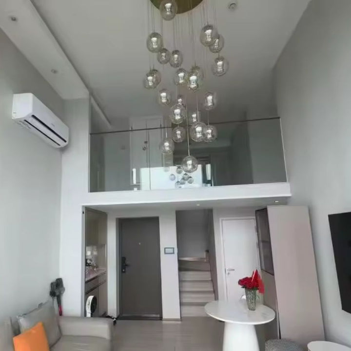 Grande suspension à globes en verre suspendus, composition aérienne et contemporaine dans un séjour avec mezzanine