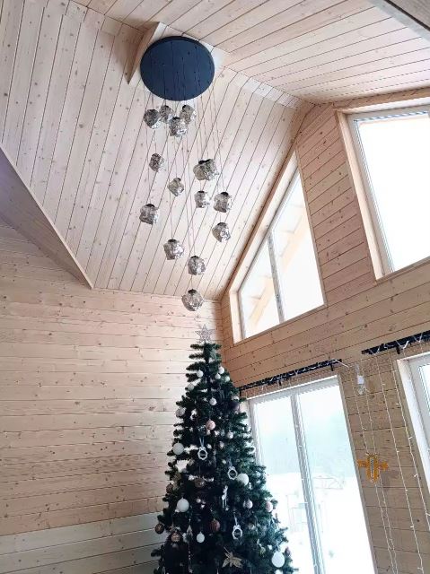 Suspension grappe en verre pour plafond incliné, luminaire moderne idéal dans une mezzanine au style chalet contemporain.