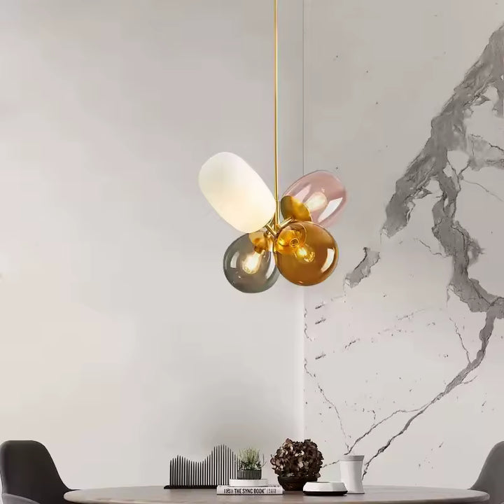 Suspension en verre coloré rétro à globes ambre, fumé, rose et opalin dans une salle à manger contemporaine