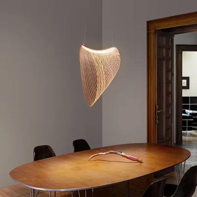 Suspension grillage dorée en bois illuminant une salle à manger avec un style moderne et chaleureux.