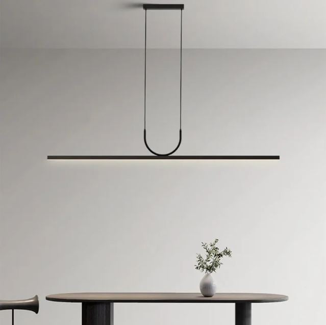 Suspension horizontale noire à éclairage LED au-dessus d’une table japandi, idéale pour une déco zen, sobre et élégante.
