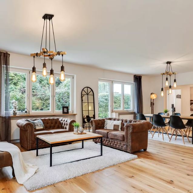 Suspension industrielle bois dans un salon style loft avec canapés en cuir, idéale pour une ambiance chaleureuse et contemporaine.