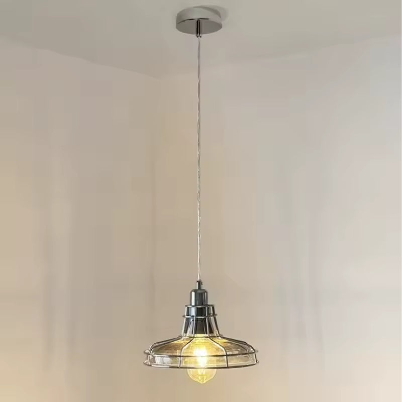 Suspendue à un long câble, cette suspension en verre transparent et chrome affiche un style atelier rétro épuré