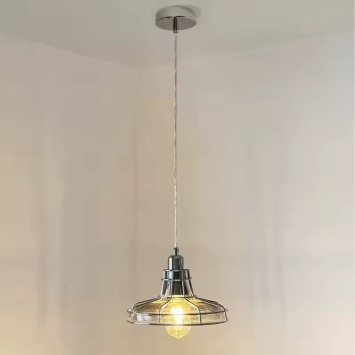 Suspendue à un long câble, cette suspension en verre transparent et chrome affiche un style atelier rétro épuré