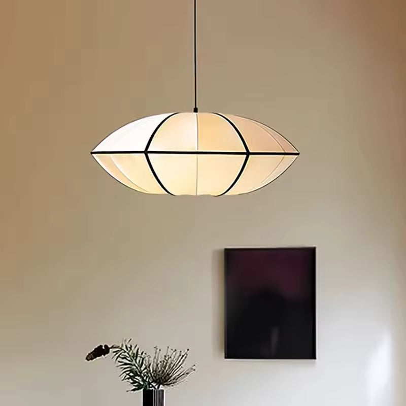 Luminaire suspendu japonais au design sculptural, avec abat-jour ovale blanc et lignes noires dans un décor minimaliste.