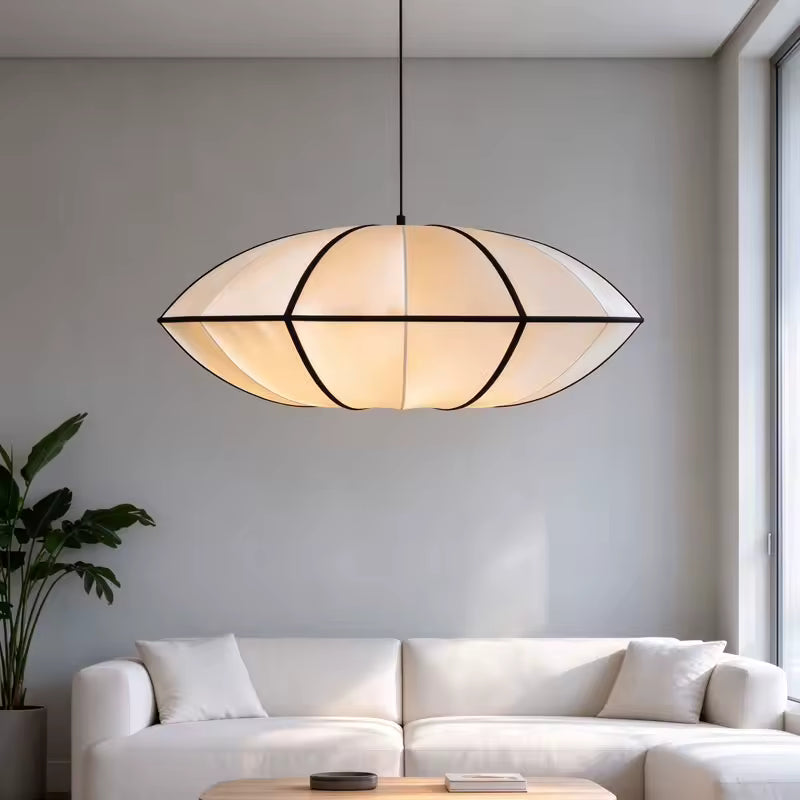 Au-dessus d'un canapé blanc, suspension japonaise ovale aux lignes noires, diffusant une lumière douce dans un salon Japandi.