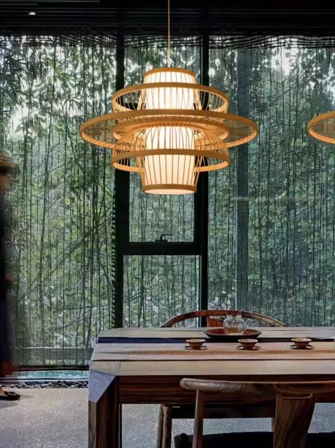 Suspension lanterne japonaise au-dessus d’une salle à manger boisée avec vue sur bambous, parfaite pour une déco naturelle et japandi.