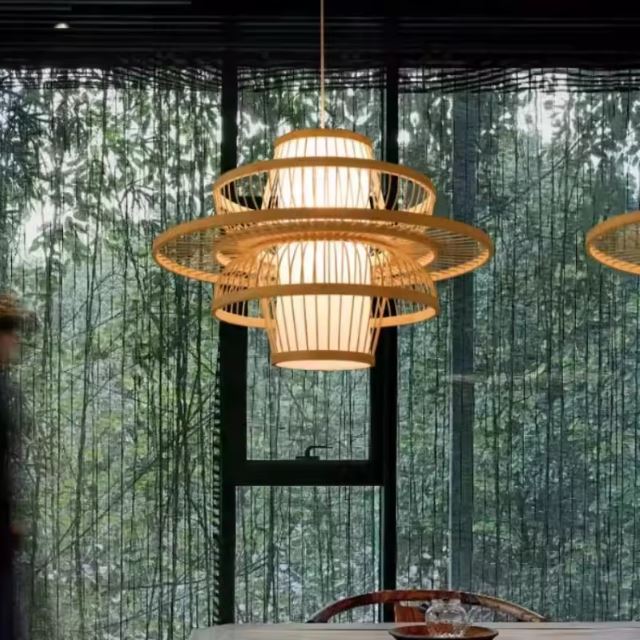 Suspension lanterne japonaise en bambou et bois, suspendue au-dessus d'une table, avec vue végétale pour une ambiance japandi.