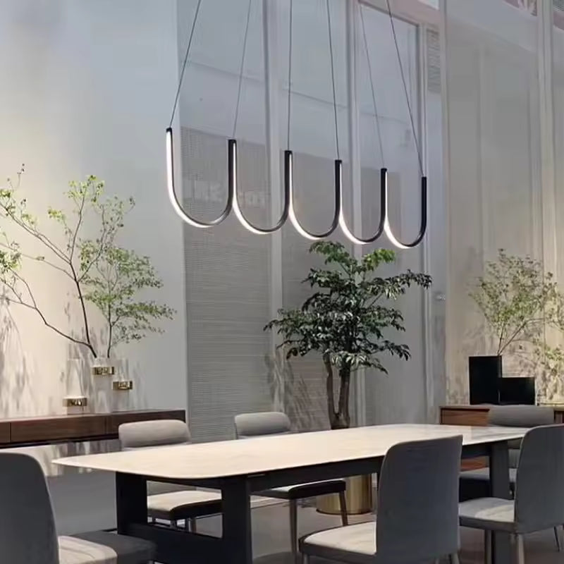 Alignement d’arceaux LED noirs au-dessus d’une table, pour une suspension minimaliste au design contemporain