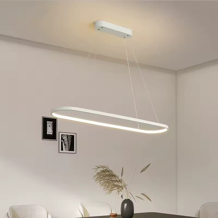 Élégante suspension LED blanche aux angles arrondis, mise en scène dans une salle à manger contemporaine