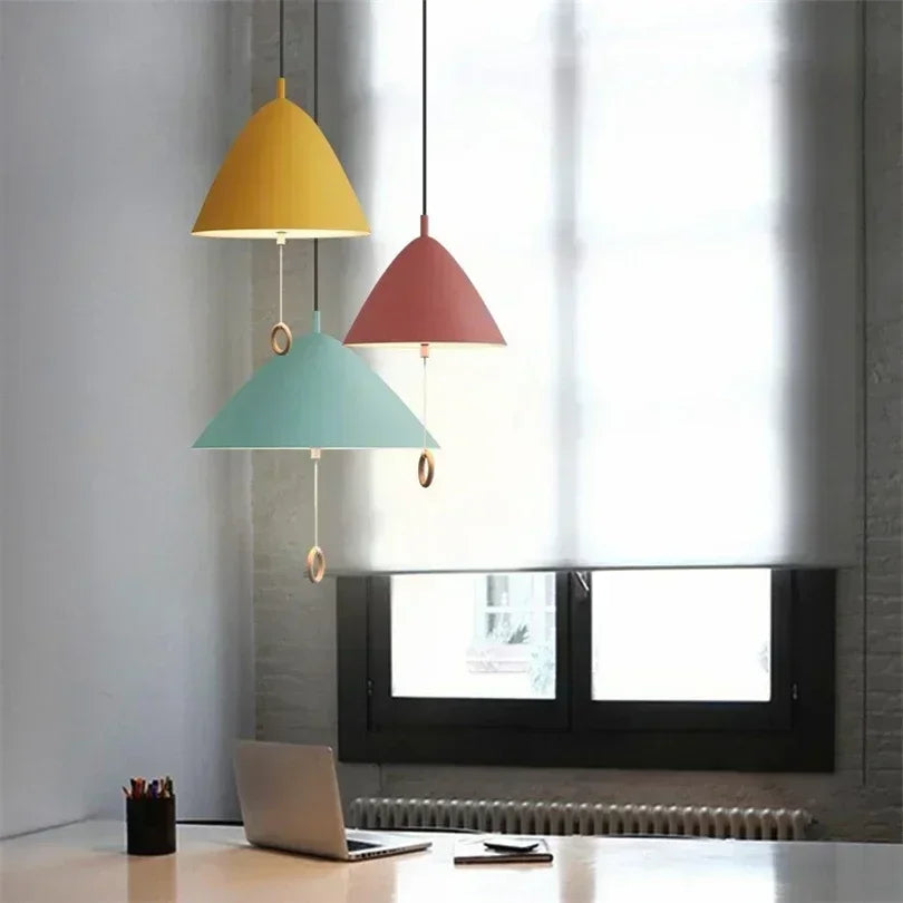 Trio de suspensions LED danoises multicolores installées dans un bureau lumineux moderne.