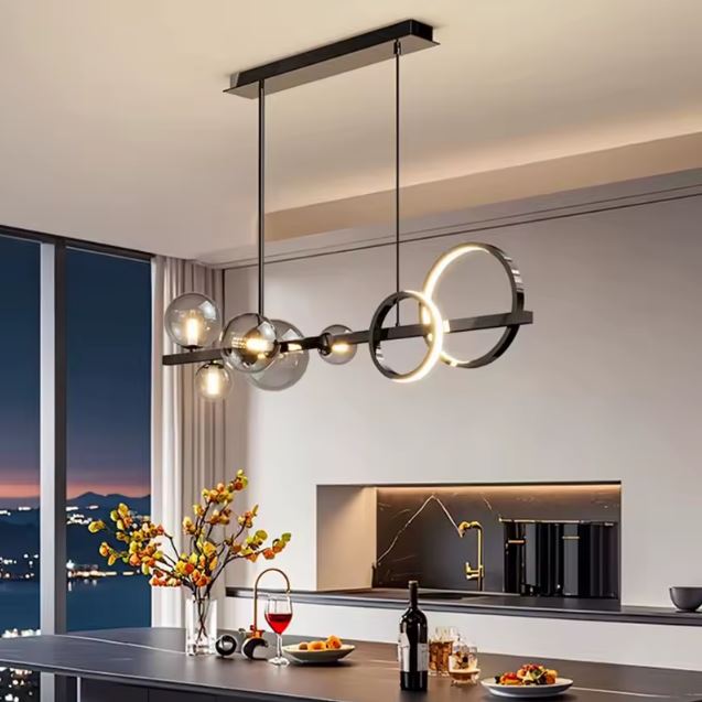 Suspension LED design avec anneaux lumineux et globes en verre fumé, apportant un éclairage moderne et élégant au-dessus d’une cuisine contemporaine.