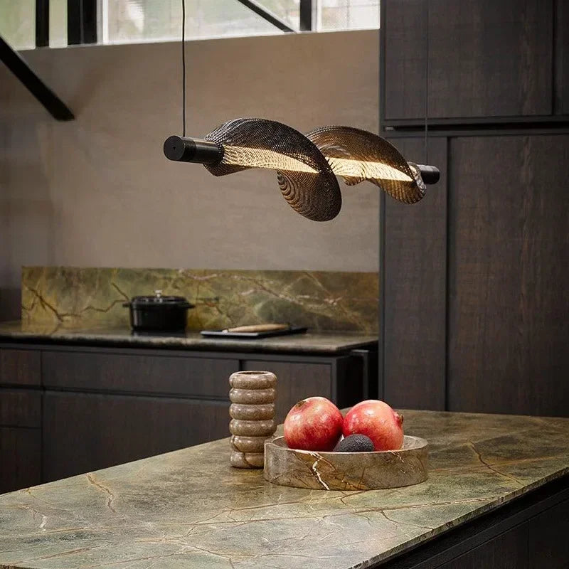 Suspension LED moderne aux lignes ondulées suspendue au-dessus d'un îlot de cuisine.
