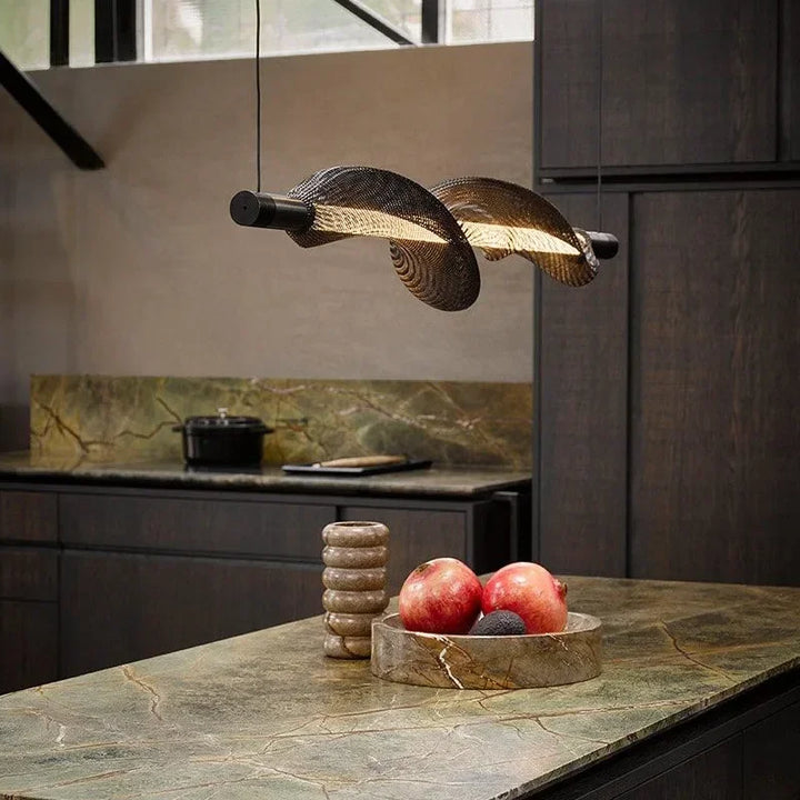Suspension LED moderne aux lignes ondulées suspendue au-dessus d'un îlot de cuisine.