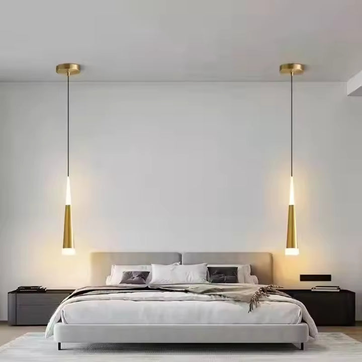 Ambiance épurée avec deux suspensions LED effilées dorées encadrant le lit dans une chambre contemporaine