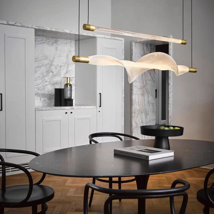 Grande suspension LED horizontale au design ondulé dans un espace décloisonné.