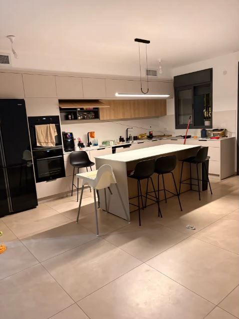 Suspension LED linéaire noire au style contemporain, luminaire suspendu idéal pour un grand îlot central de cuisine moderne.