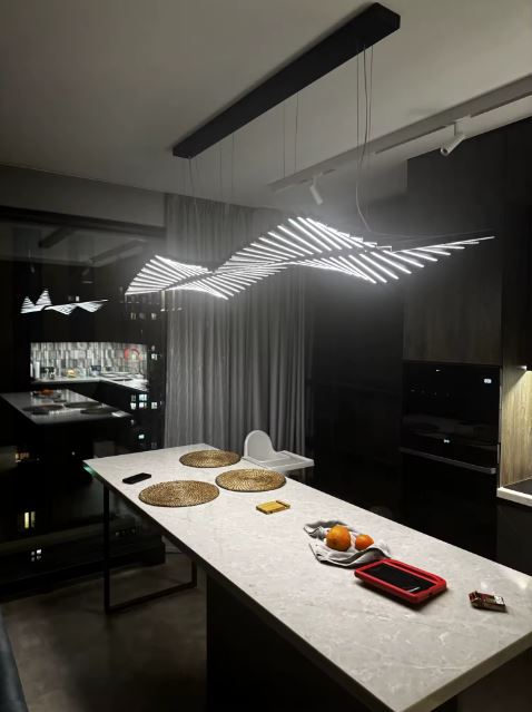 Suspension LED noire à structure aérienne et graphique, esprit design avant-gardiste pour îlot de cuisine.