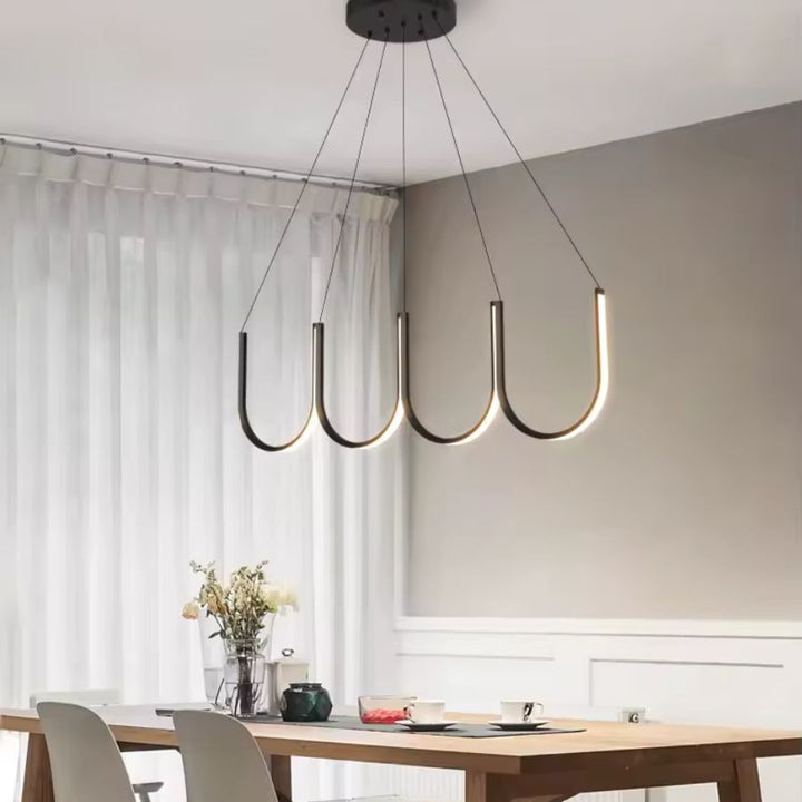 Dans une salle à manger épurée, suspension LED noire à quatre arceaux courbés au style moderne et aérien