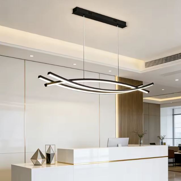 Suspension LED noire au dessin graphique et aérien, idéale pour un espace d’accueil contemporain.