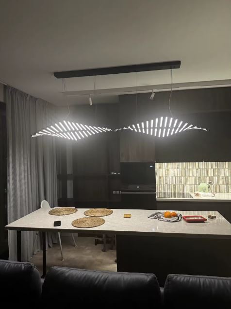 Suspension LED noire en éventail lumineux, style futuriste et minimaliste pour cuisine contemporaine.