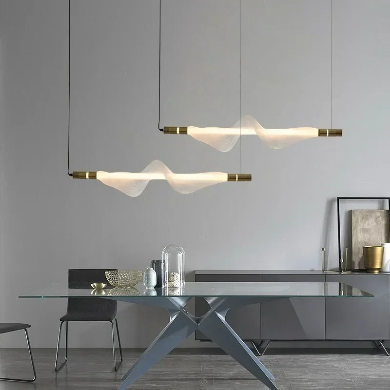 Double suspension LED à ondulation moderne installée au-dessus d'une table de salle à manger.