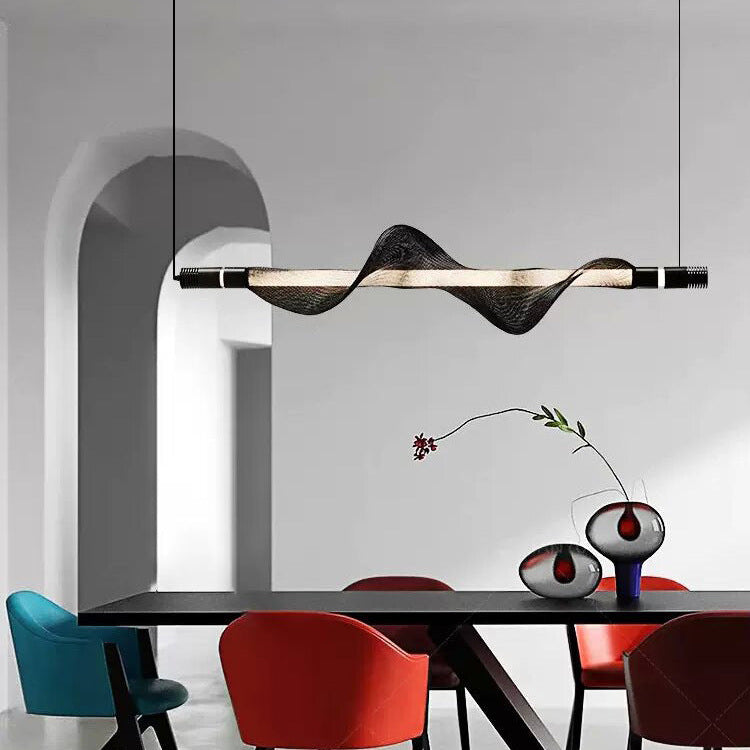 Suspension LED à ondulation moderne illuminant une grande table de salle à manger.