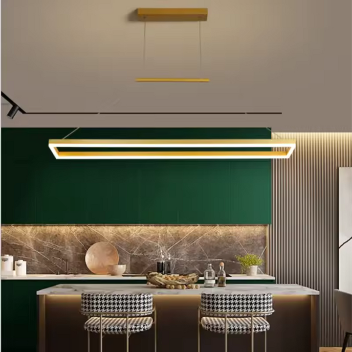 Suspension LED rectangulaire dorée au style moderne et luxueux, mise en scène au-dessus d’un îlot de cuisine
