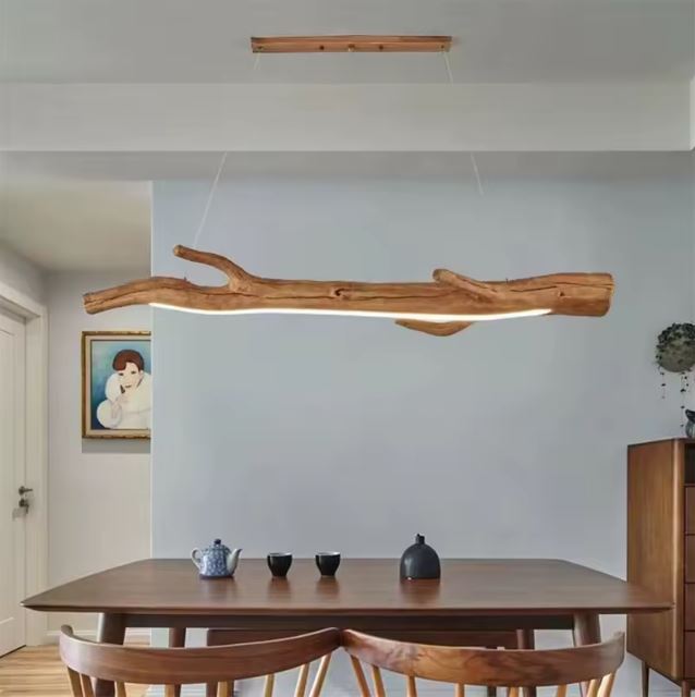 Suspension rondin de bois LED au-dessus d'une table à manger, idéale pour un intérieur chaleureux et naturel.