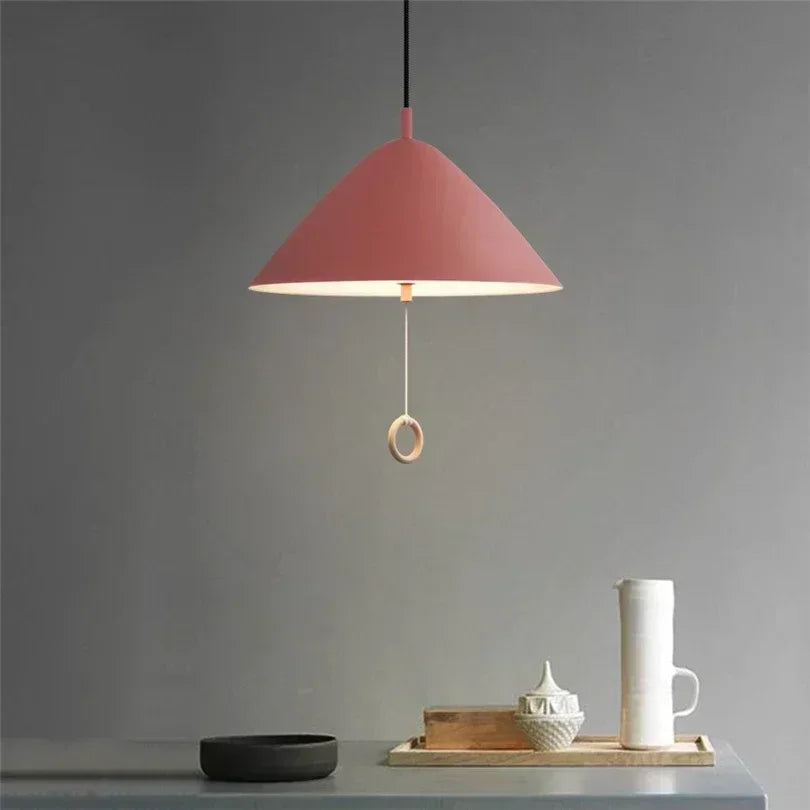 Suspension LED rose au design scandinave épuré dans une cuisine minimaliste.