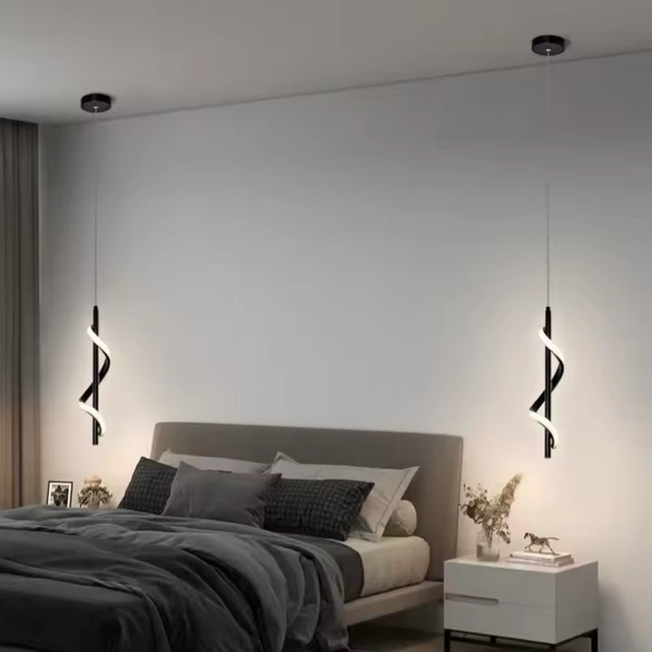 De part et d'autre du lit, deux suspensions LED noires en spirale hélicoïdale apportent une touche design à la chambre.