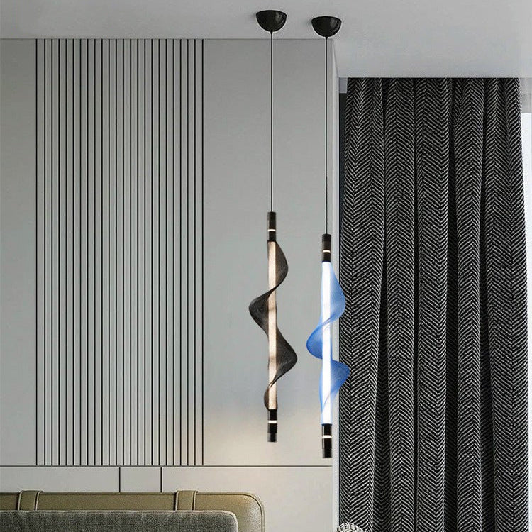 Suspension LED verticale au design ondulé installée dans une chambre à coucher.