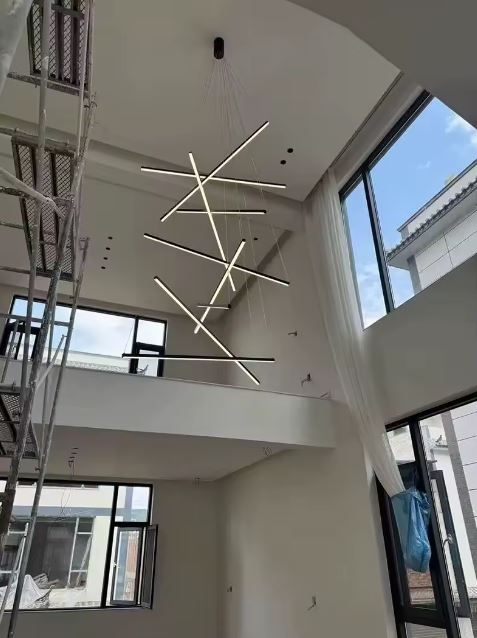 Suspension LED verticale effet sculpture lumineuse, idéale pour une cage d'escalier ou un salon à très haut plafond au style épuré.